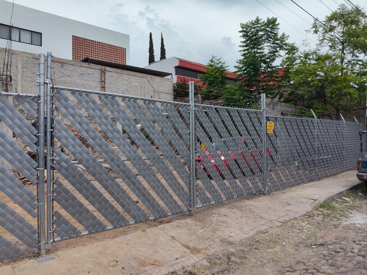 Malla ciclónica con tiras de privacidad grises recién instalada